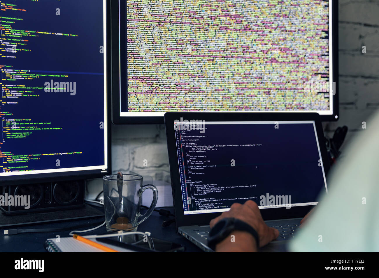 programmer web developer working on multiple computers Stock Photo