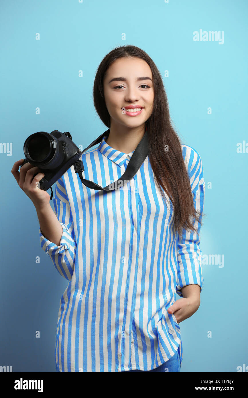 Beautiful young photographer on color background Stock Photo - Alamy