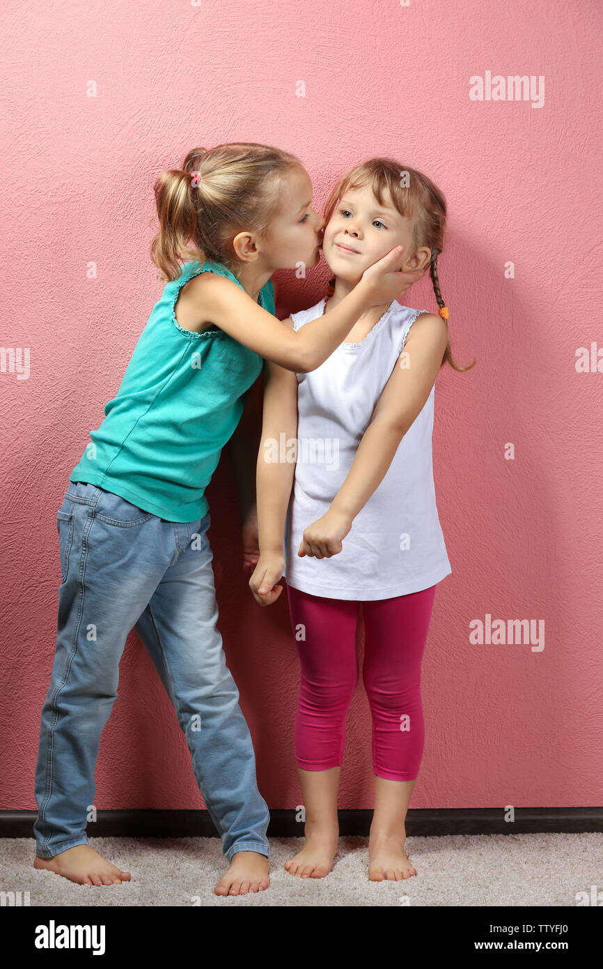 Adorable little girls on pink background Stock Photo