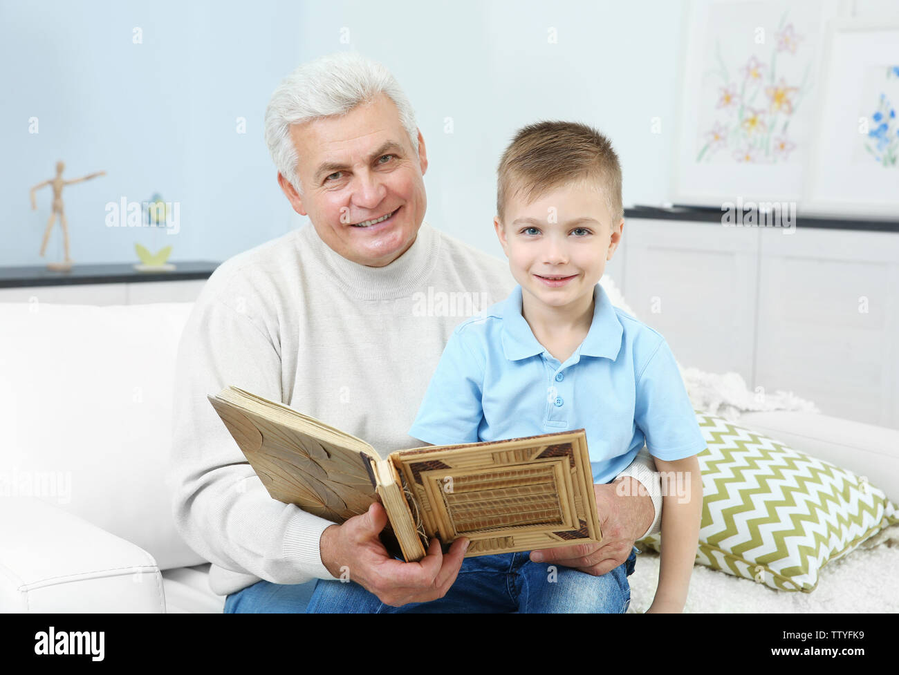 Grandfather looking at photo album with his grandchild Stock Photo - Alamy