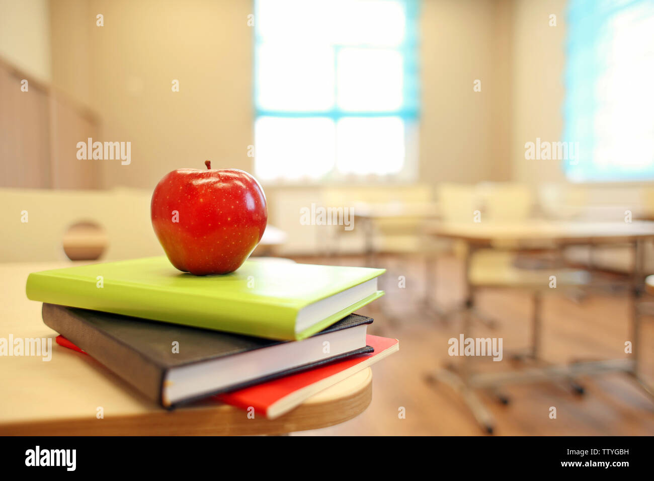 Stack of books and apple on desk at classroom Stock Photo Alamy