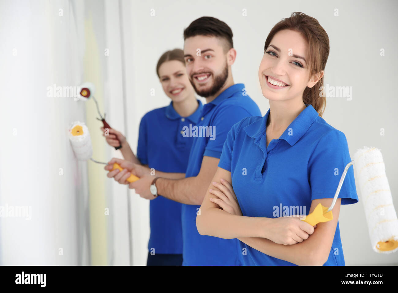 Young decorators painting wall in room Stock Photo