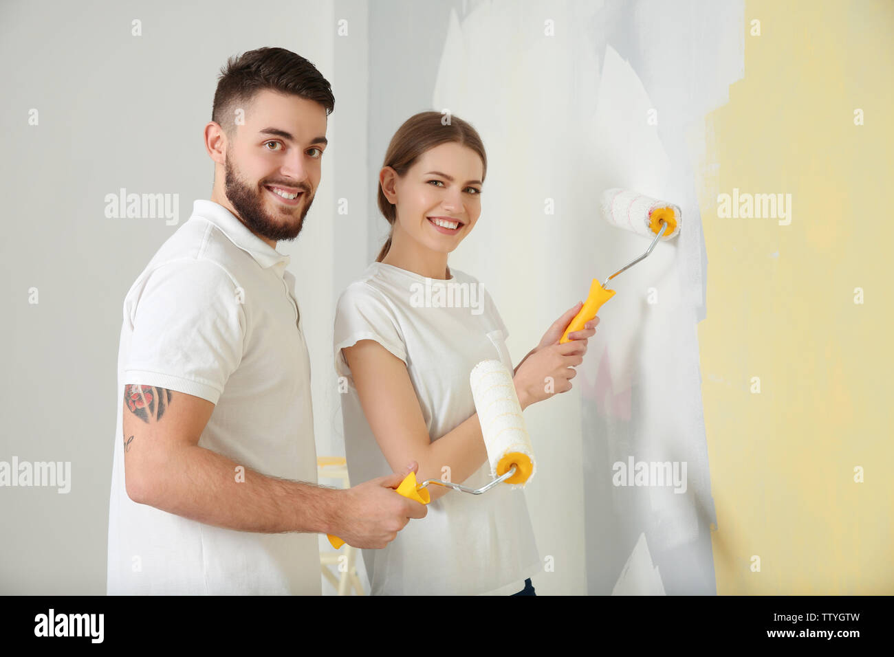 Young decorators painting wall in room Stock Photo