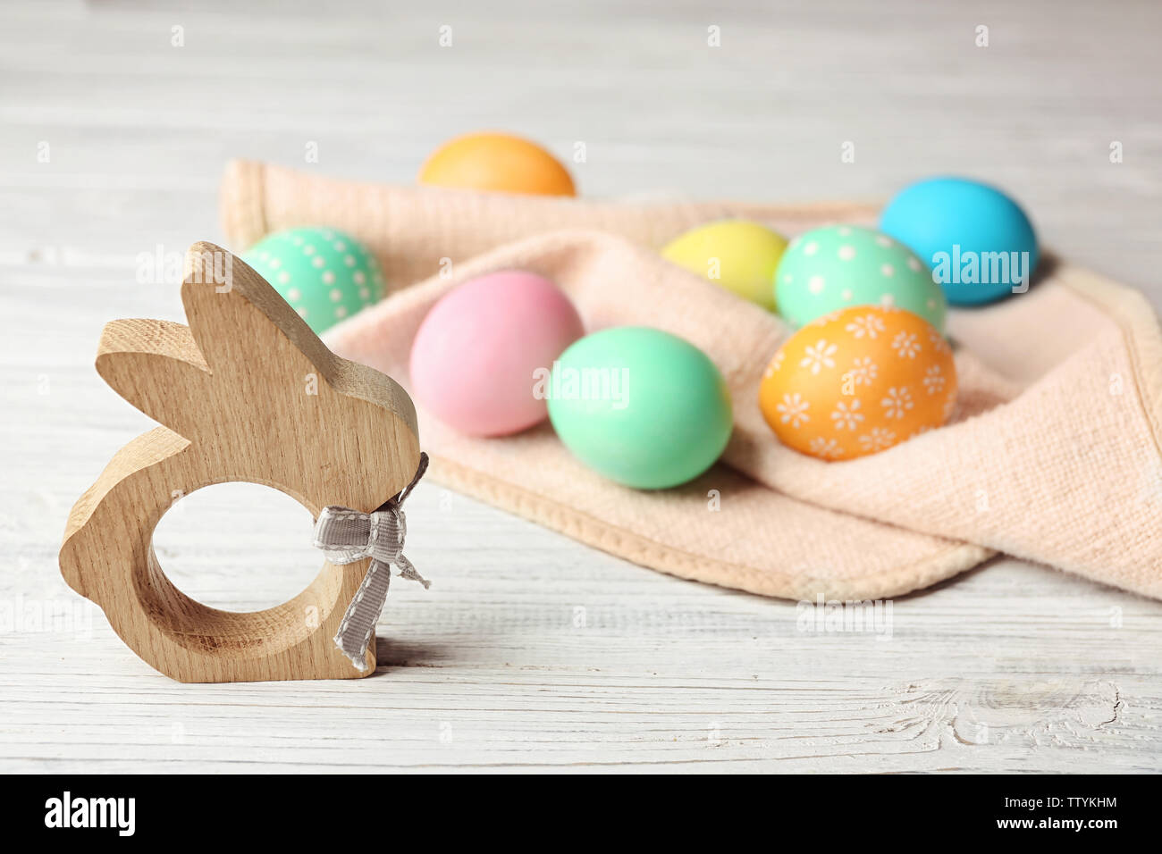 Bunny figure and colorful Easter eggs on wooden table Stock Photo