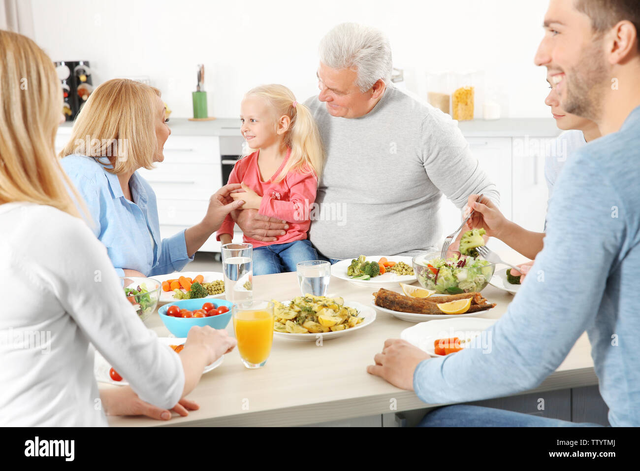 Happy family having lunch in kitchen Stock Photo