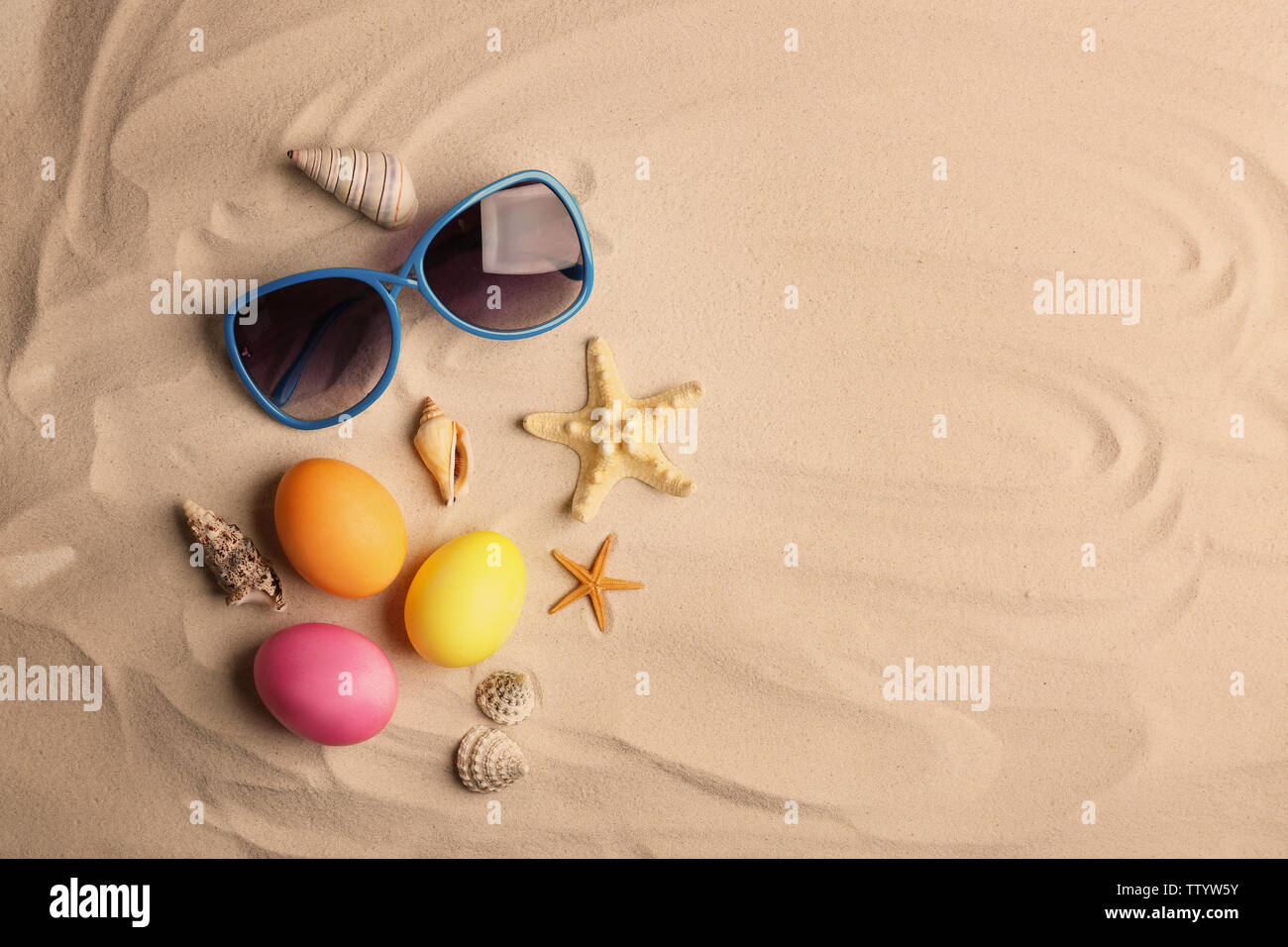 Easter eggs with sunglasses on sand Stock Photo
