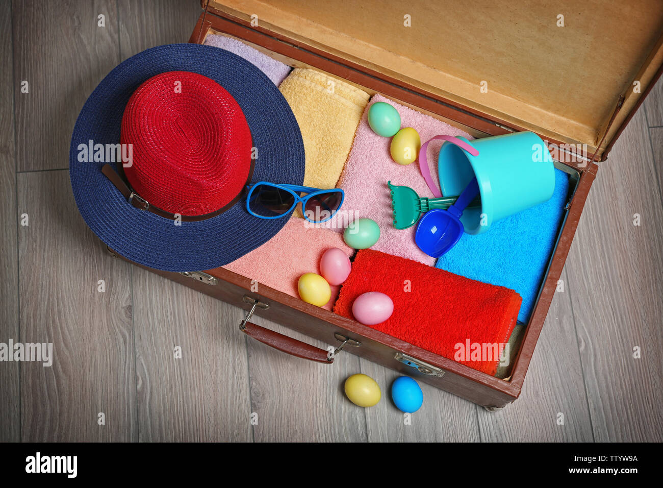 Easter eggs with open suitcase on floor Stock Photo