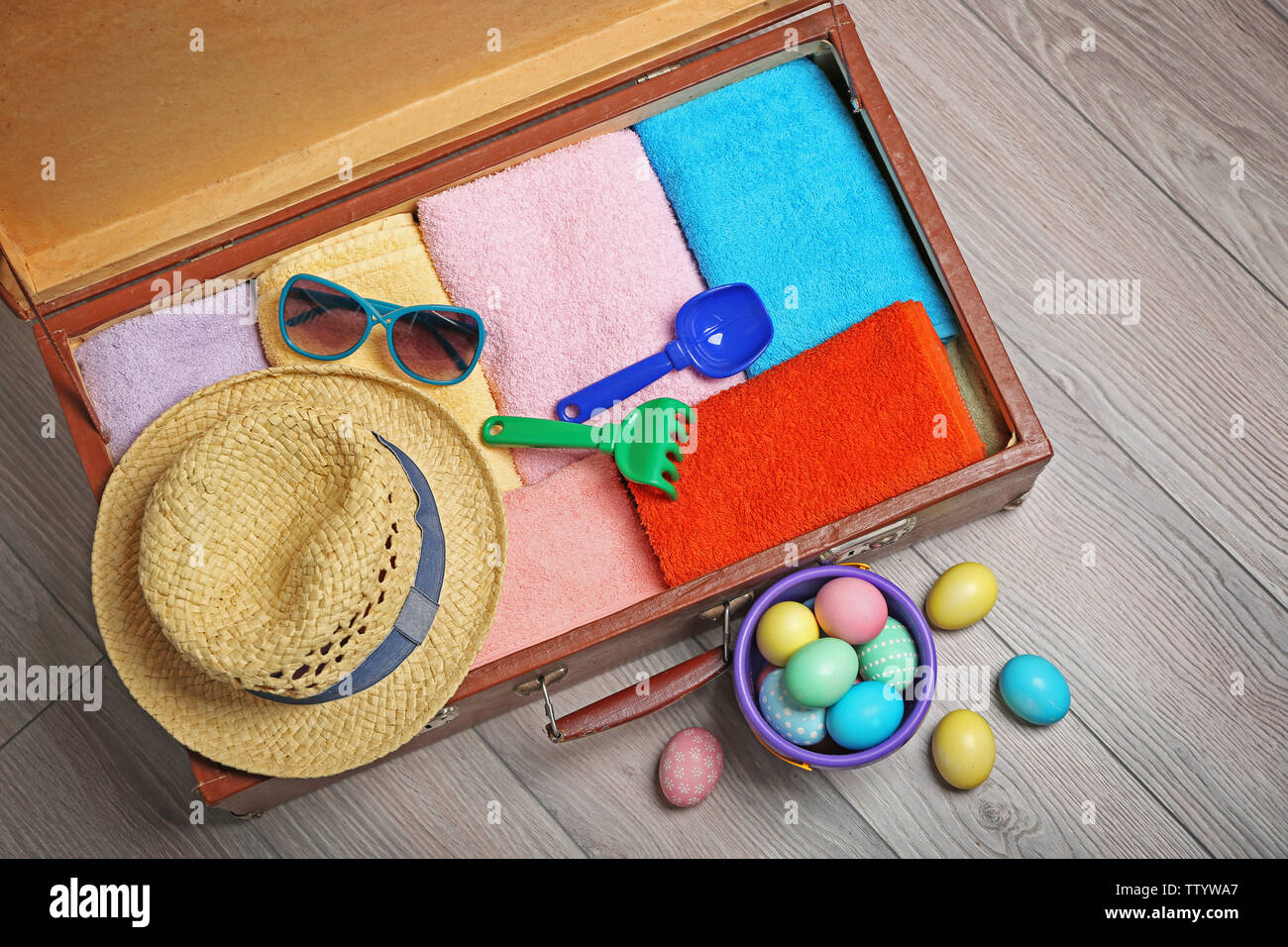 Easter eggs with open suitcase on floor Stock Photo