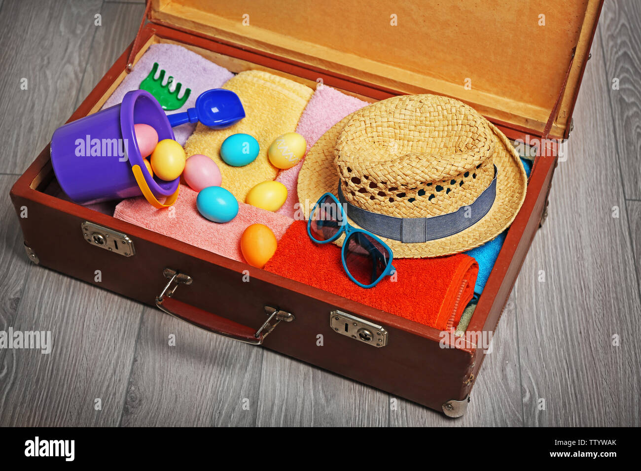 Easter eggs with open suitcase on floor Stock Photo