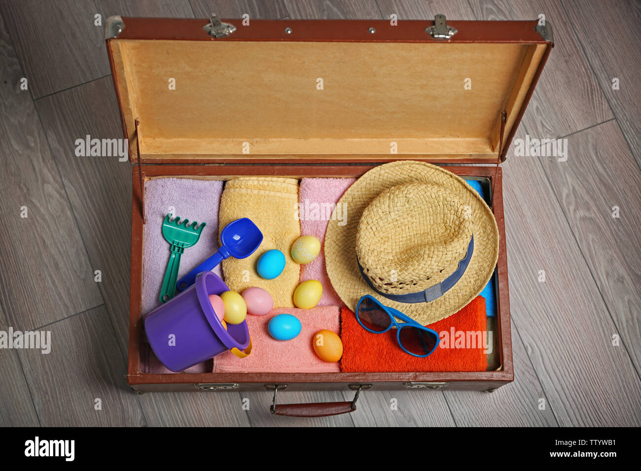 Easter eggs with open suitcase on floor Stock Photo