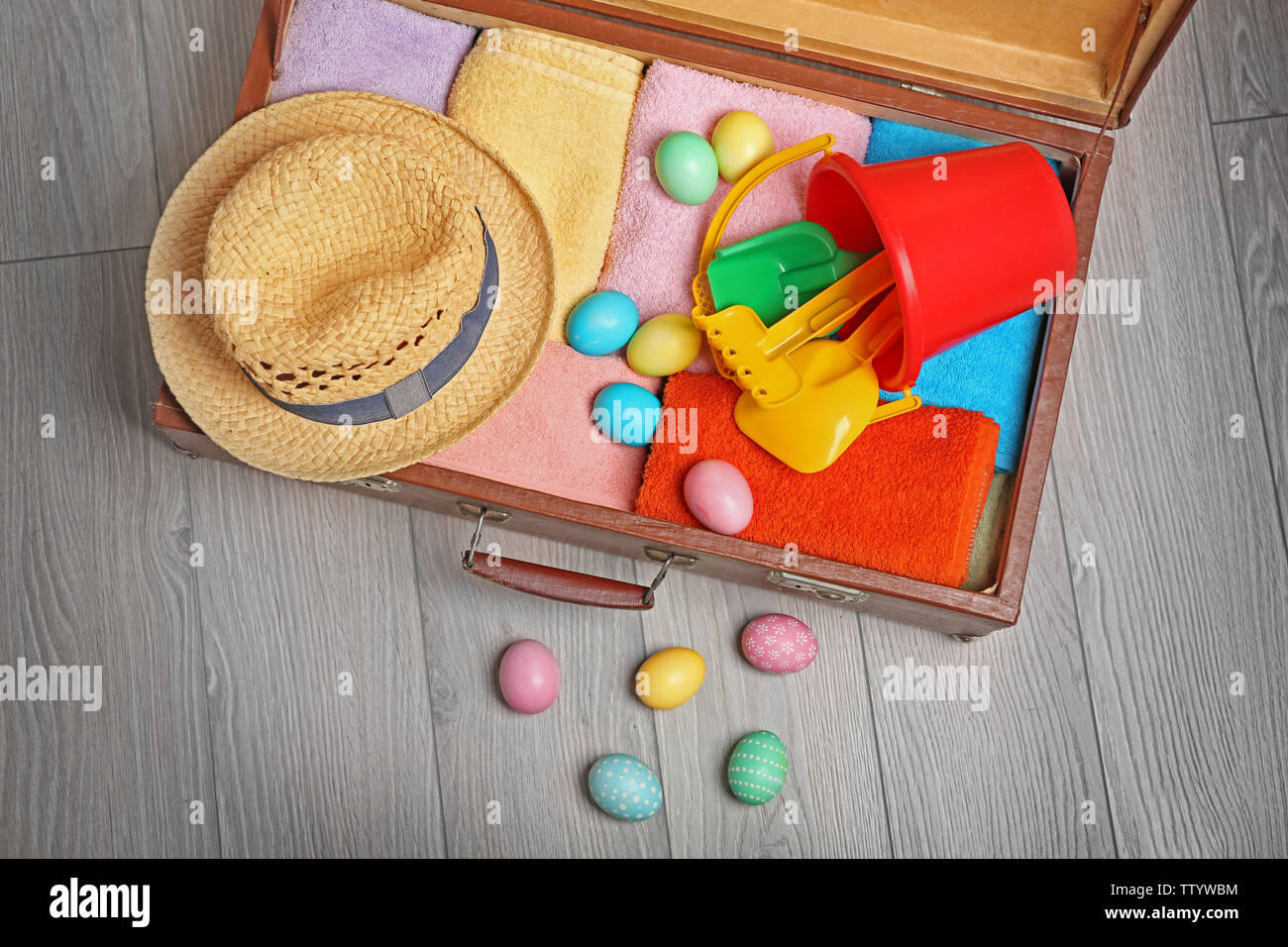 Easter eggs with open suitcase on floor Stock Photo