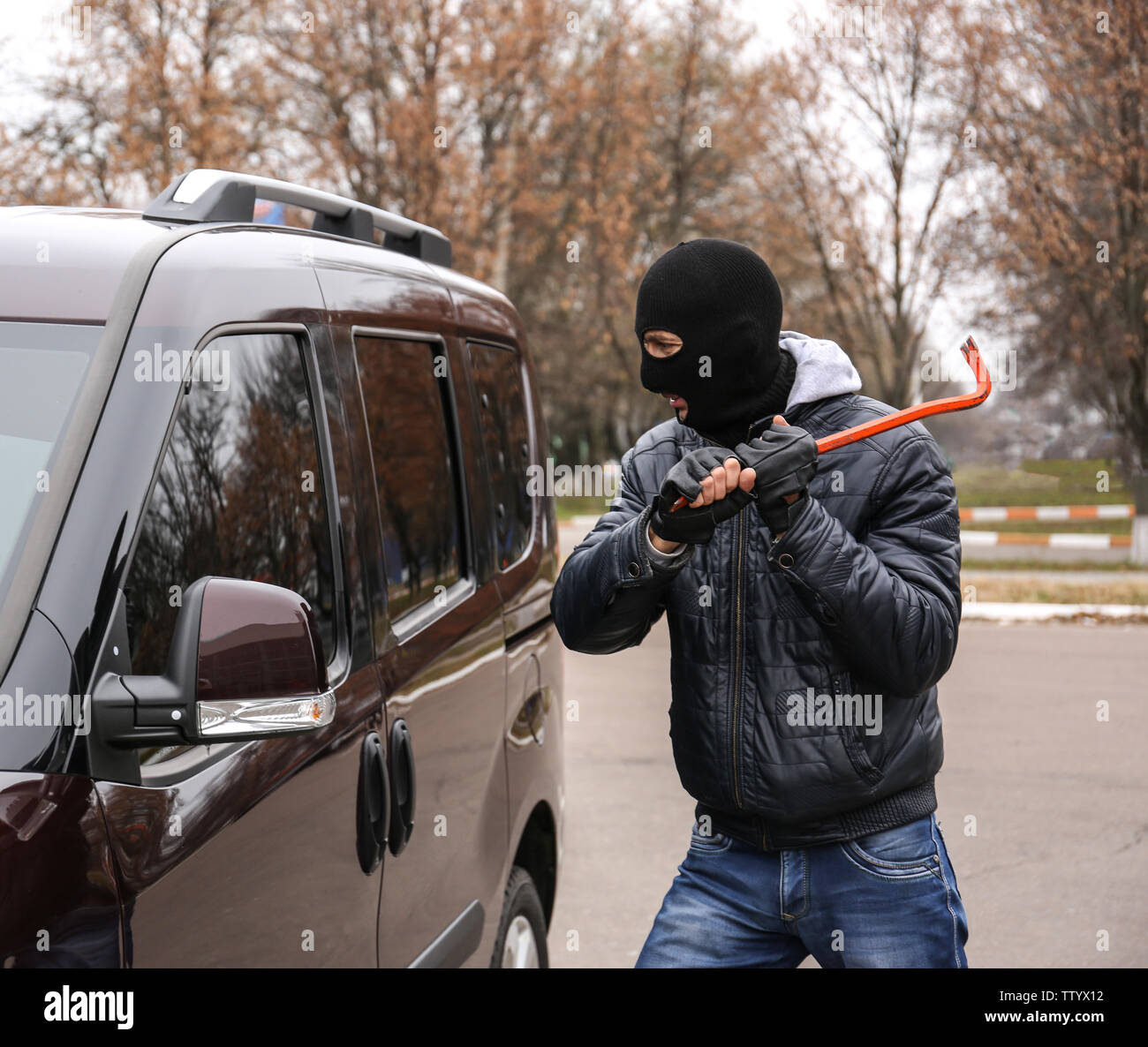 Male thief going to break car window with crowbar Stock Photo Alamy