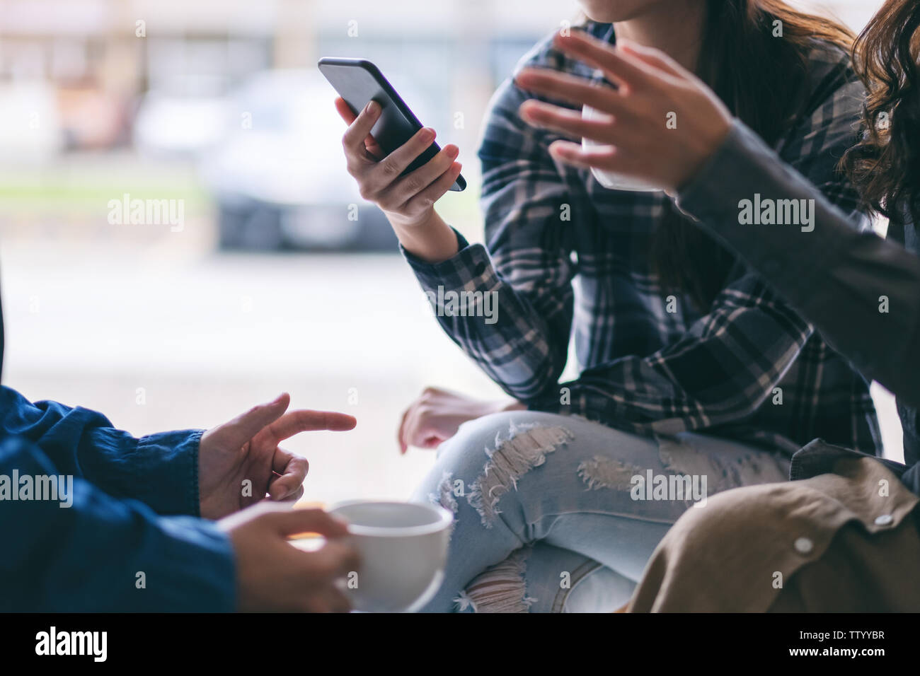 People using phone, talking and drinking coffee together Stock Photo