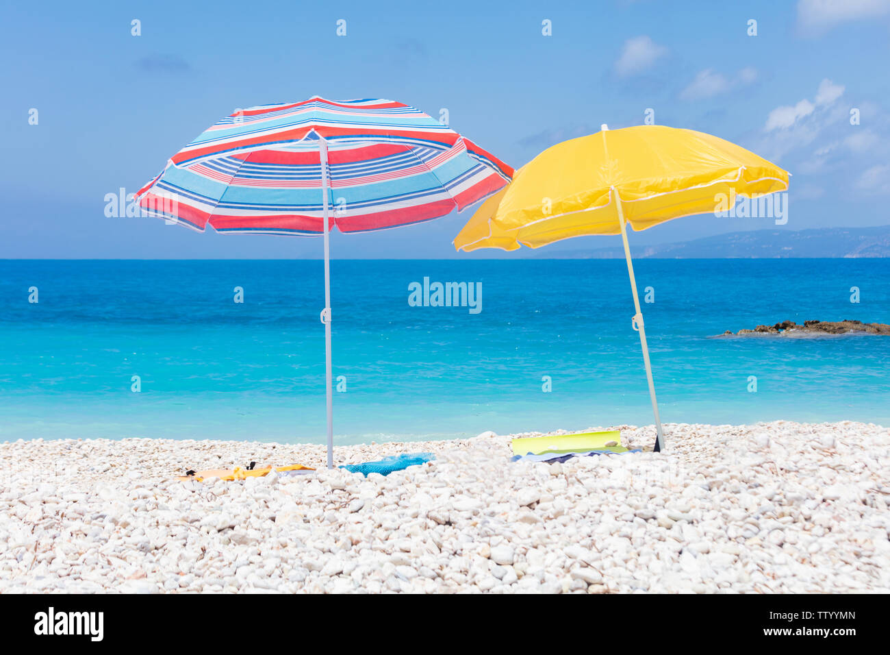 Two umbrellas with bedding on the white beach Stock Photo