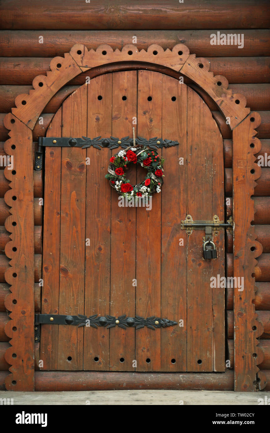Floral wreath with beautiful flowers hanging on vintage wooden door ...