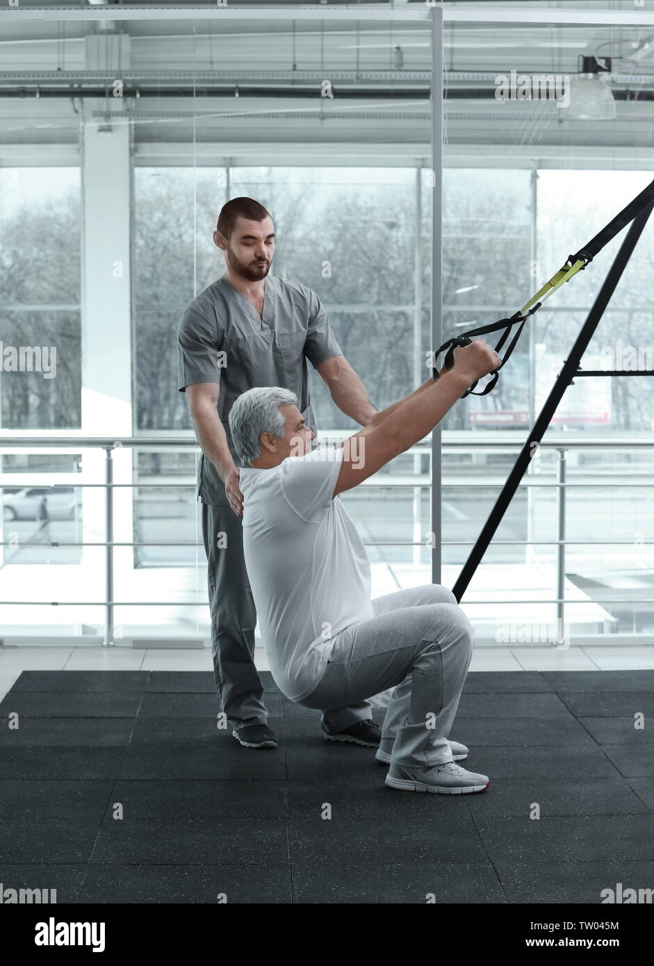 Rehabilitation concept. Mature man doing exercises under ...