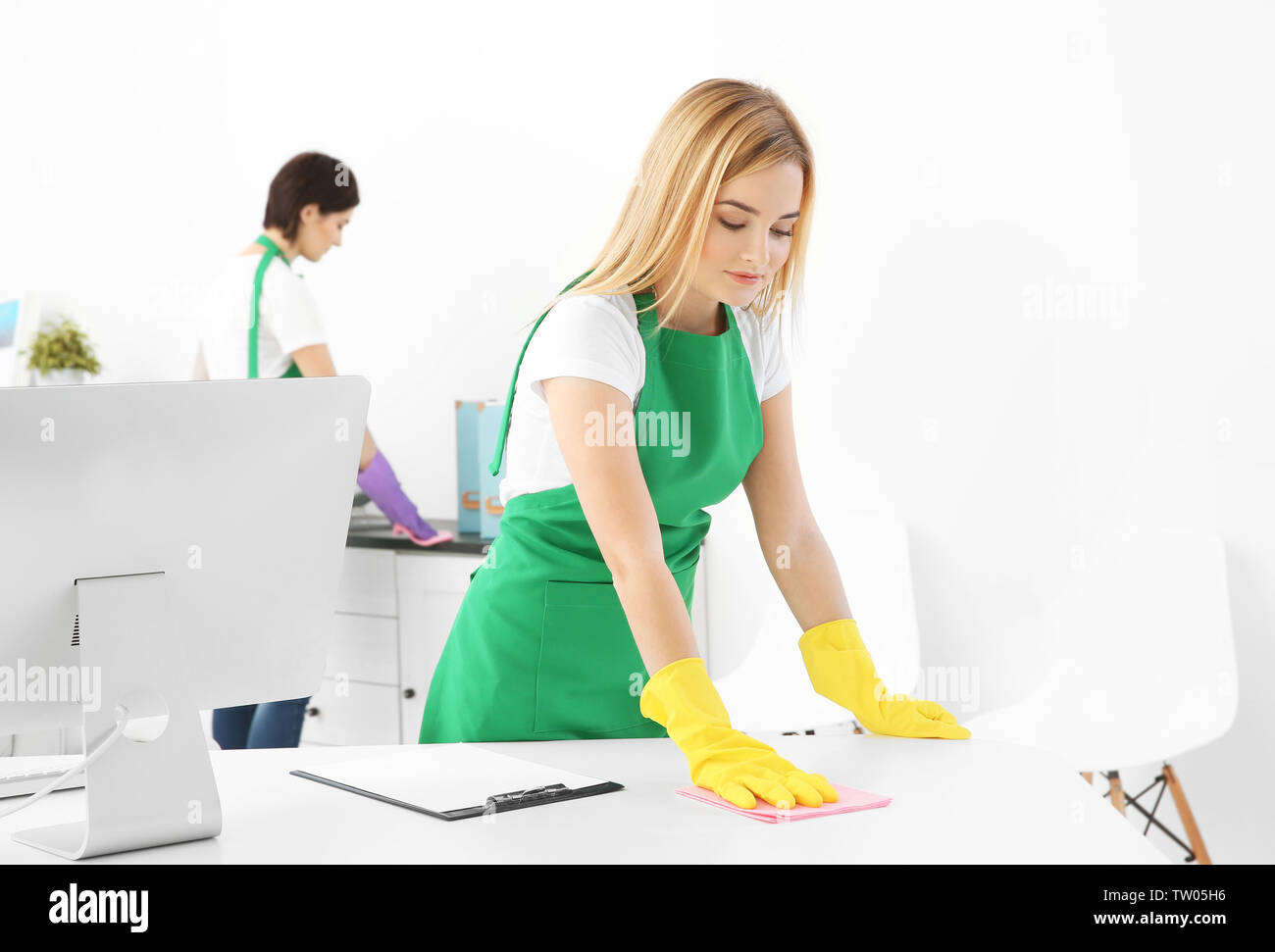 Young woman cleaning office table Stock Photo - Alamy
