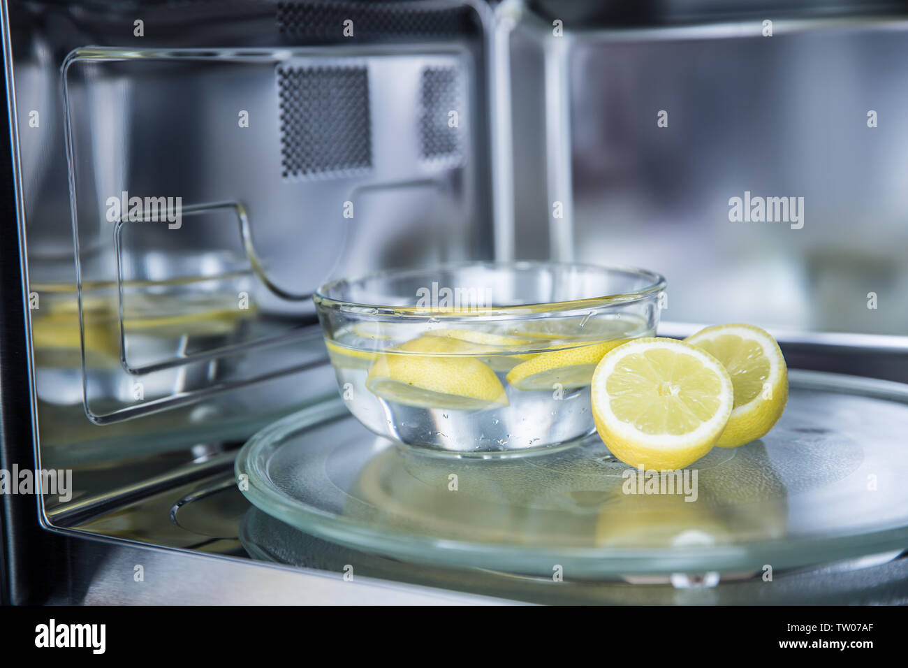 A method of cleaning in a microwave oven with water and lemon. Stock Photo