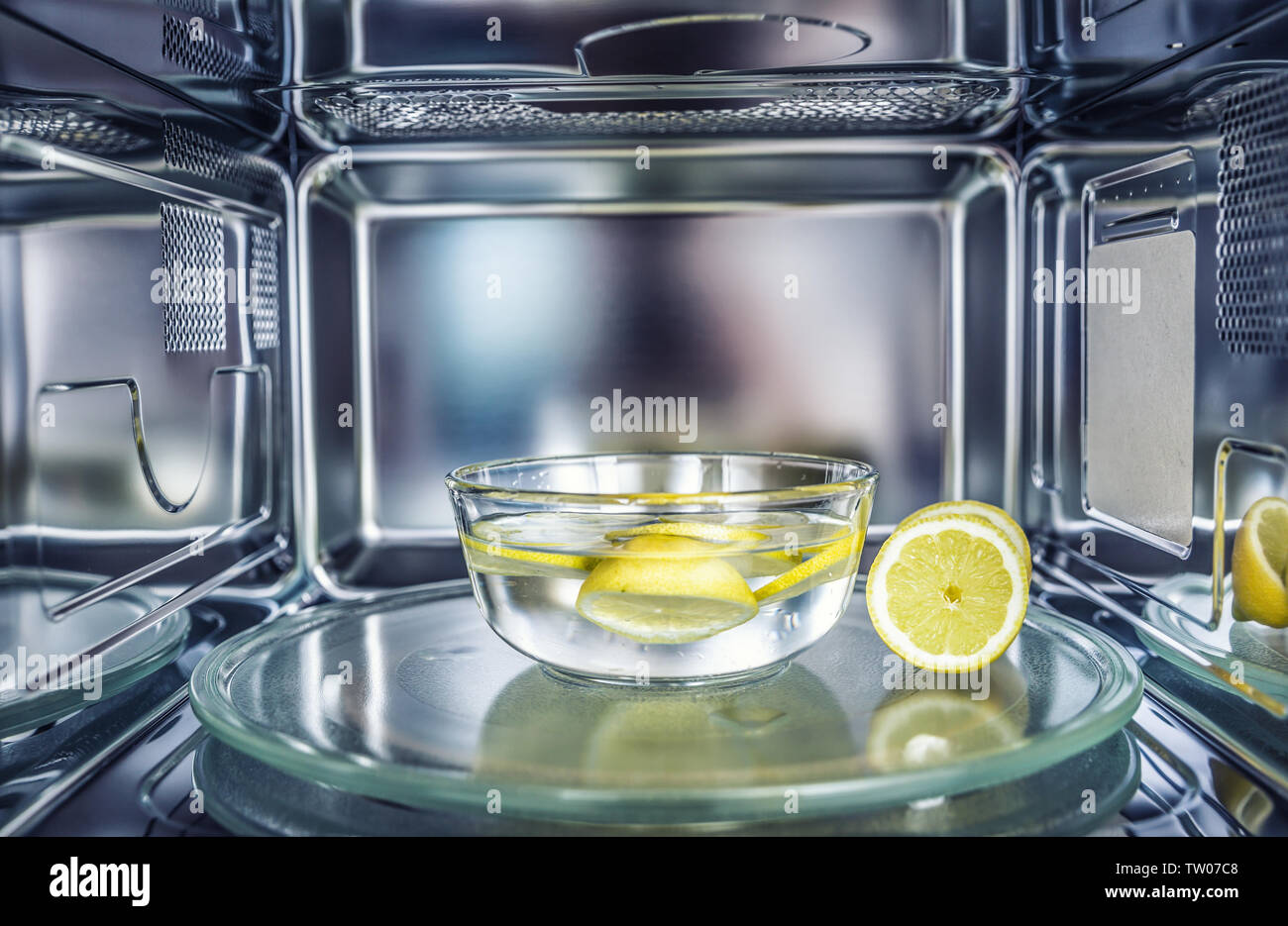 A method of cleaning in a microwave oven with water and lemon. Stock Photo