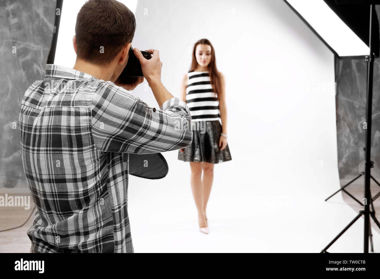 Photographer Using Model Photographer working with model in studio Stock Photo - Alamy