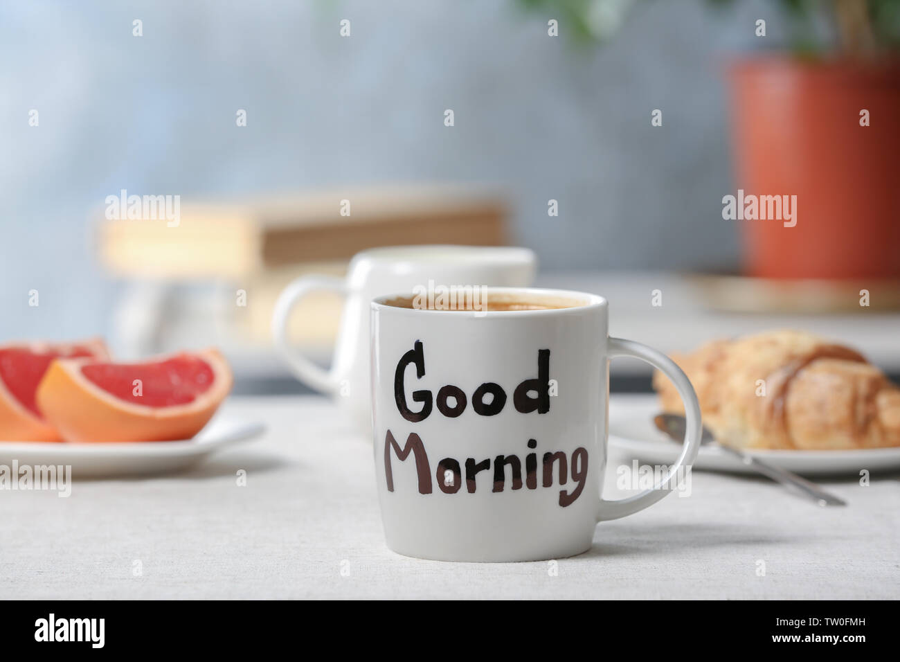 Words GOOD MORNING written on cup with breakfast on background ...