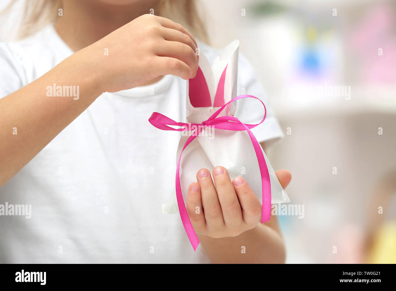 Cute little child holding paper bag in shape of Easter rabbit, closeup Stock Photo