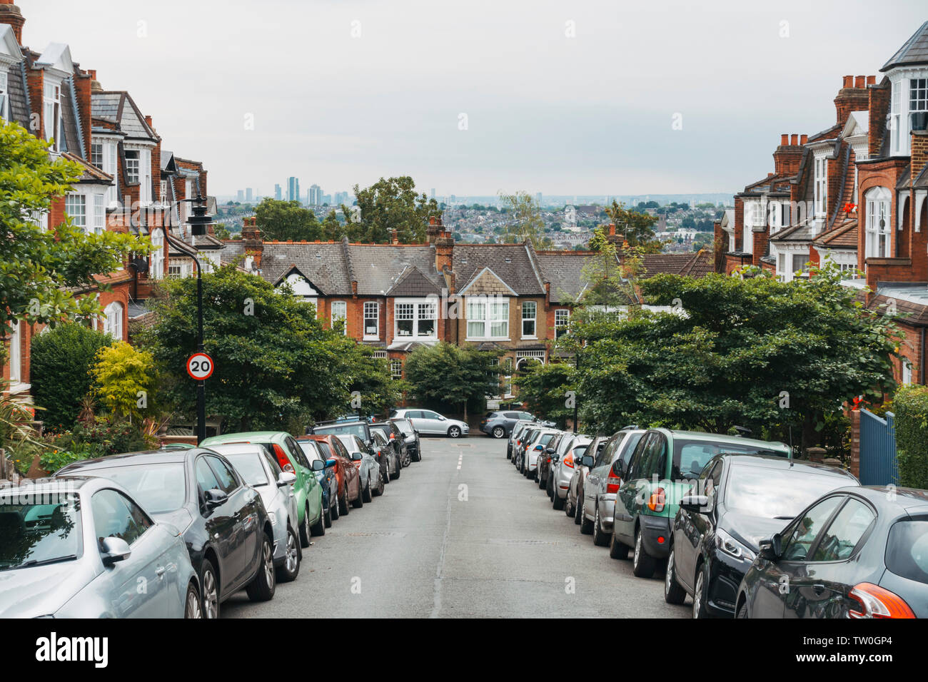 Looking down the peaceful terrace-housed streets of Muswell Hill, North London, on a muggy summer's morning. London skyline is visible behind Stock Photo