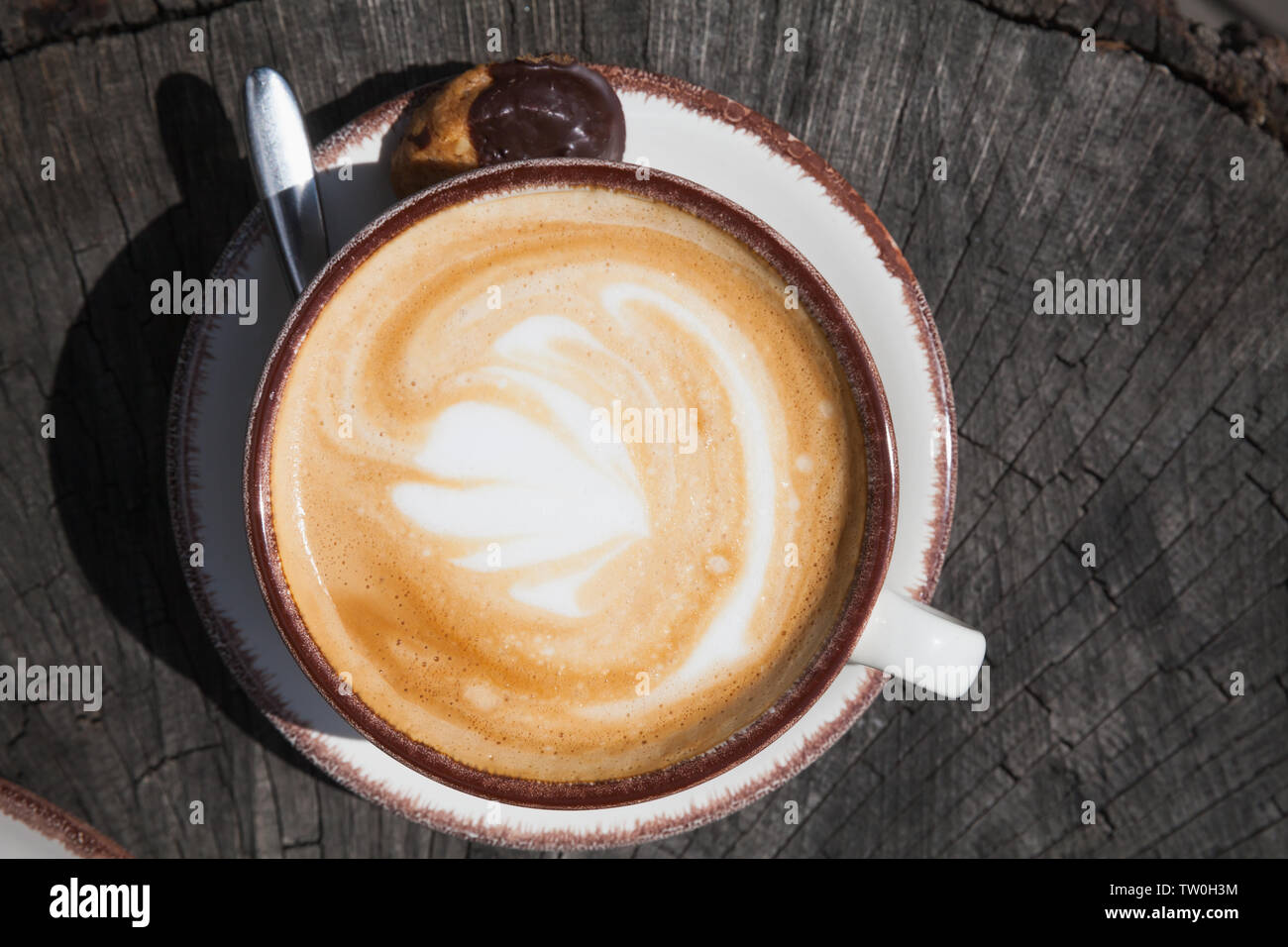 Cappuccino coffee, top view. Cup of coffee with milk foam stands on vintage wooden table Stock Photo