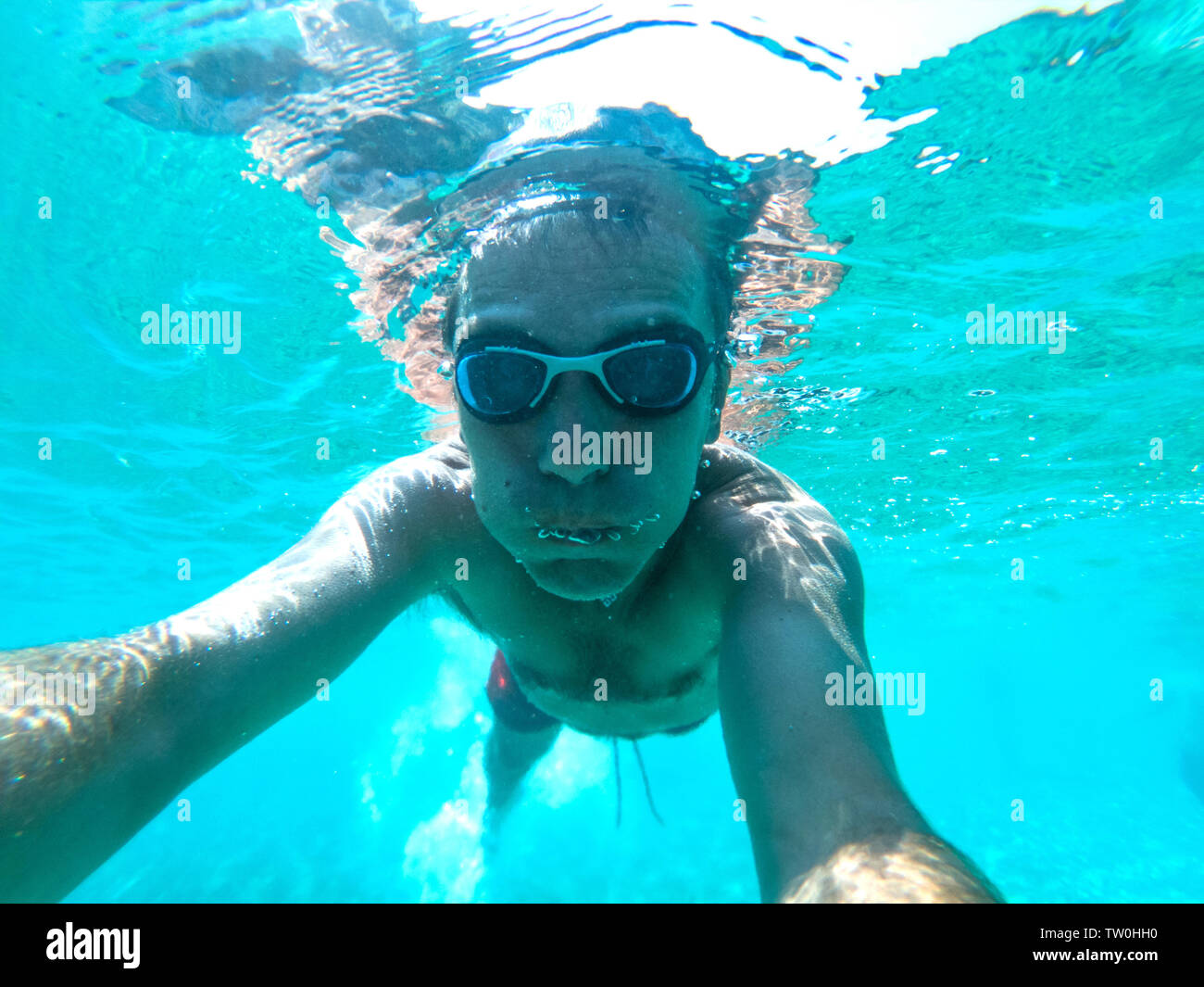 Underwater view of a young diver man swimming in the sea. Air bubbles  coming out from mouth and nose Stock Photo - Alamy