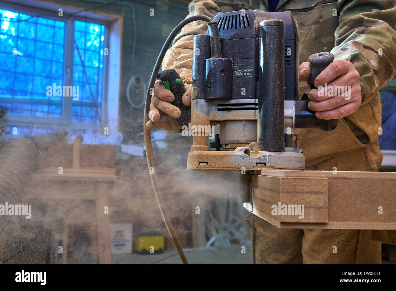 Carpenter working with manual hand milling machine in the