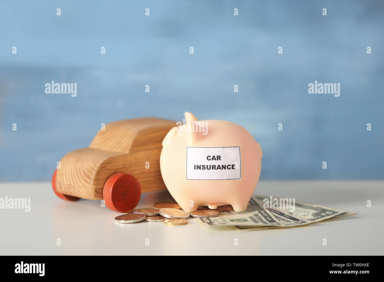 Piggy bank with wooden toy car on table Stock Photo