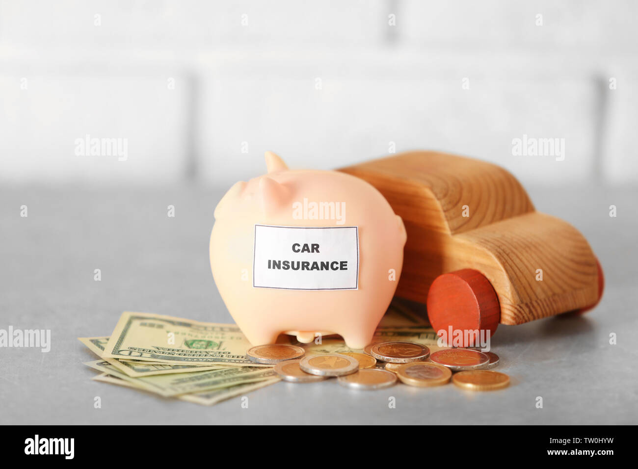 Piggy bank with wooden toy car on light background Stock Photo