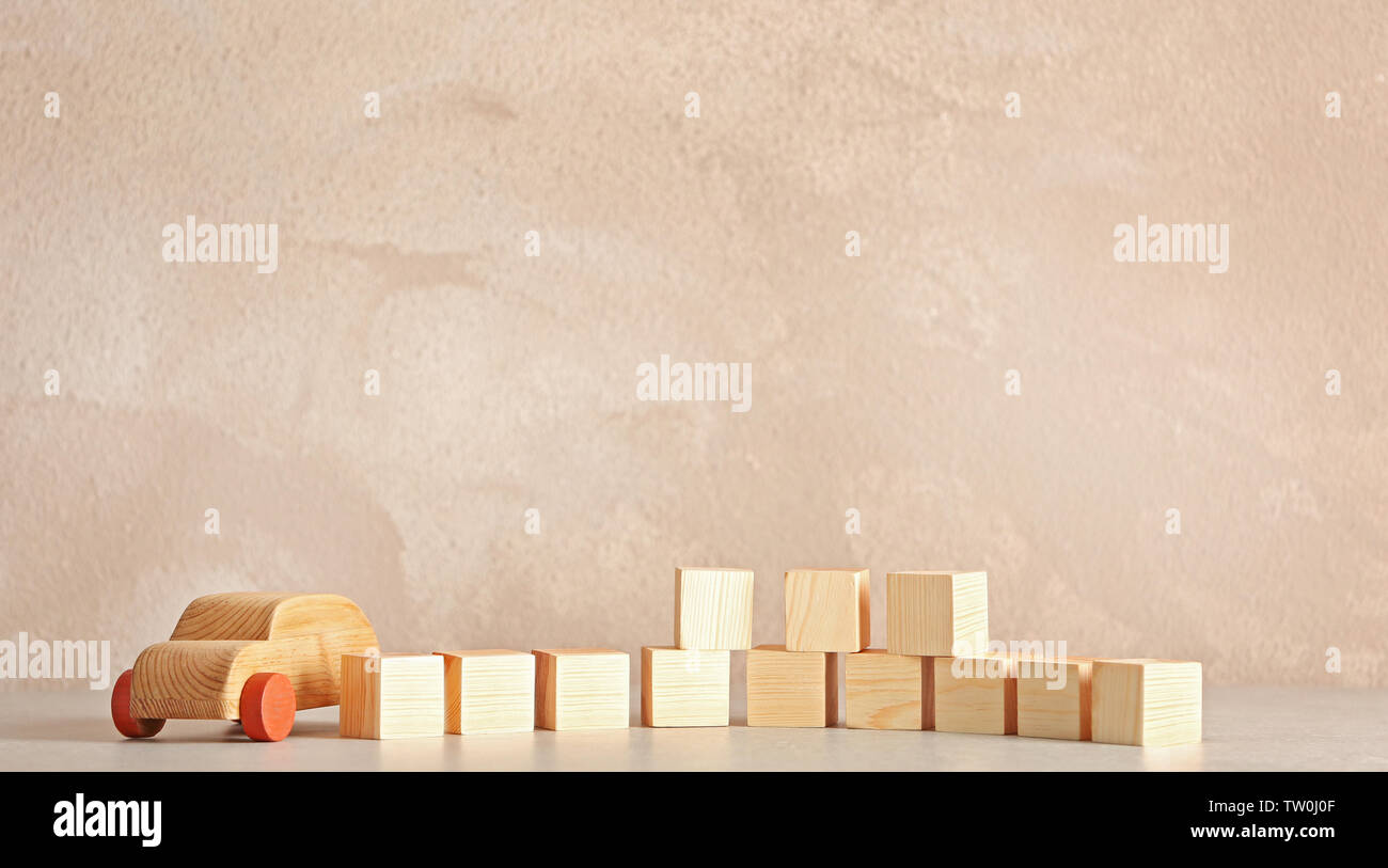Cubes with space for text and wooden toy car on light background Stock Photo