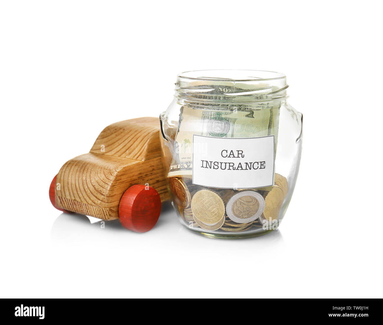 Glass jar with money and wooden car toy on white background Stock Photo
