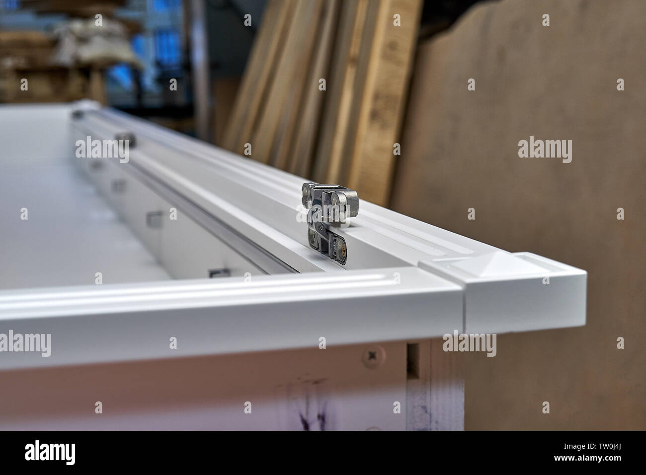 White with hidden hinges and shelf holders. Closeup. Wooden