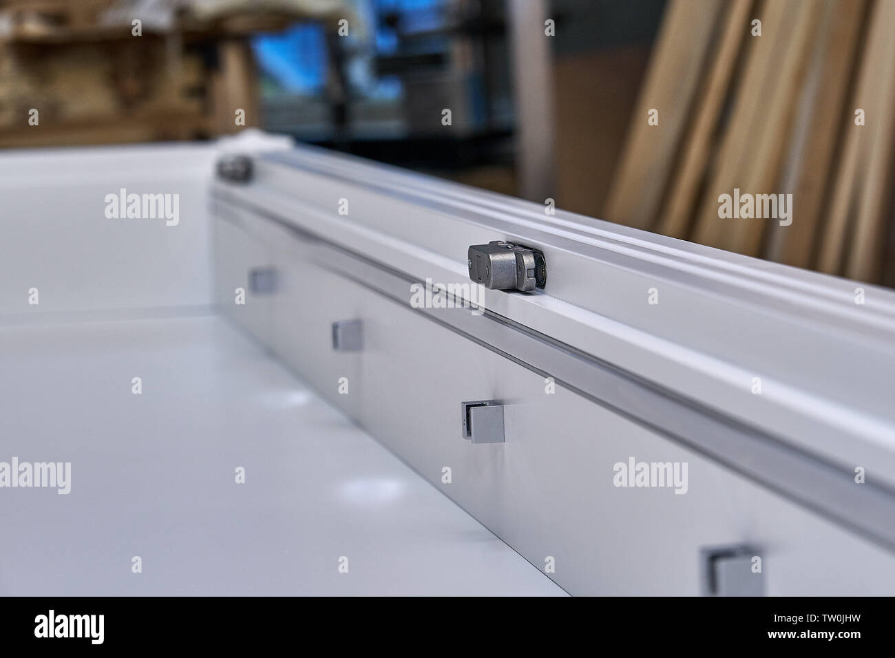 White with hidden hinges and shelf holders. Closeup. Wooden