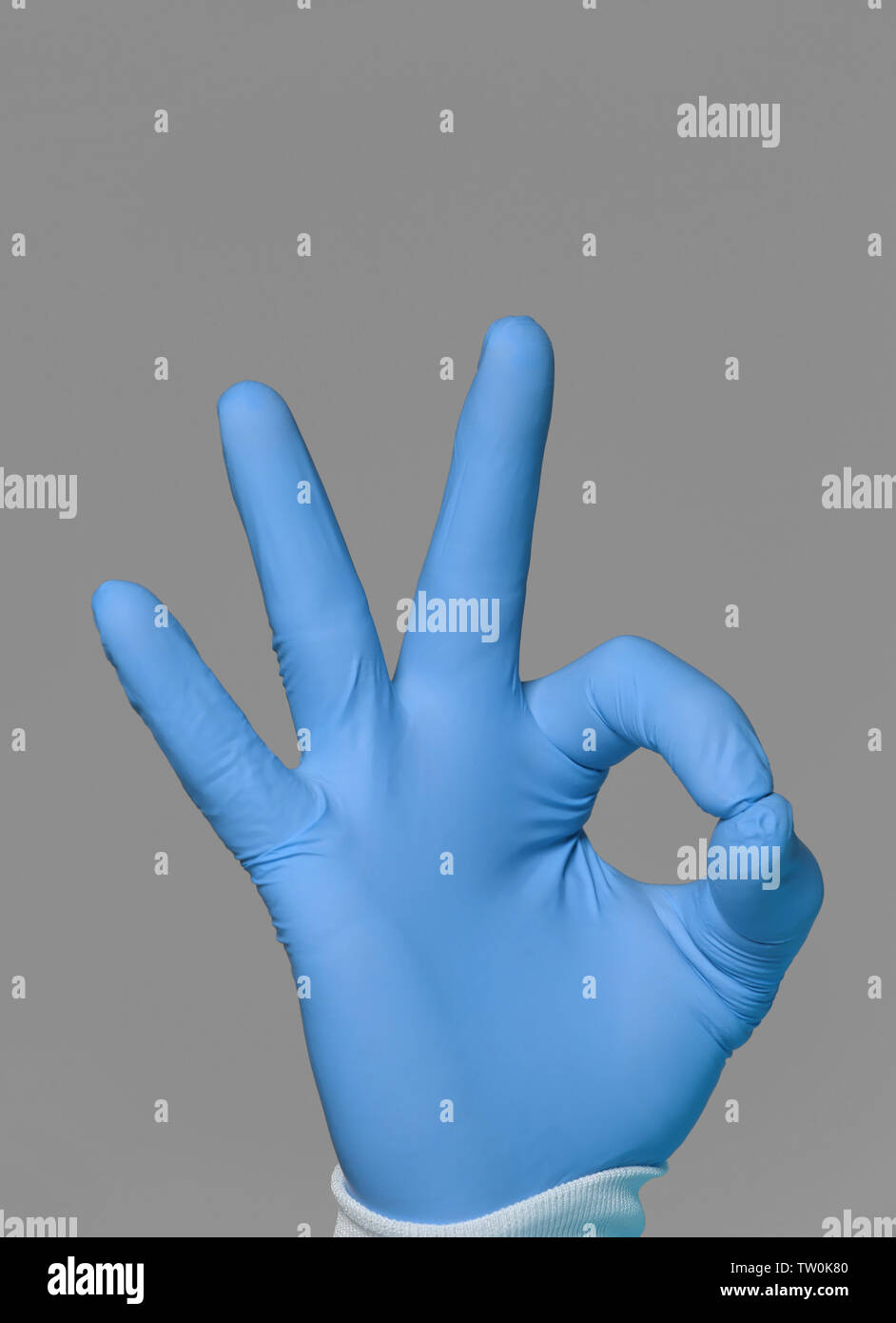Hand of doctor making OK sign on grey background Stock Photo