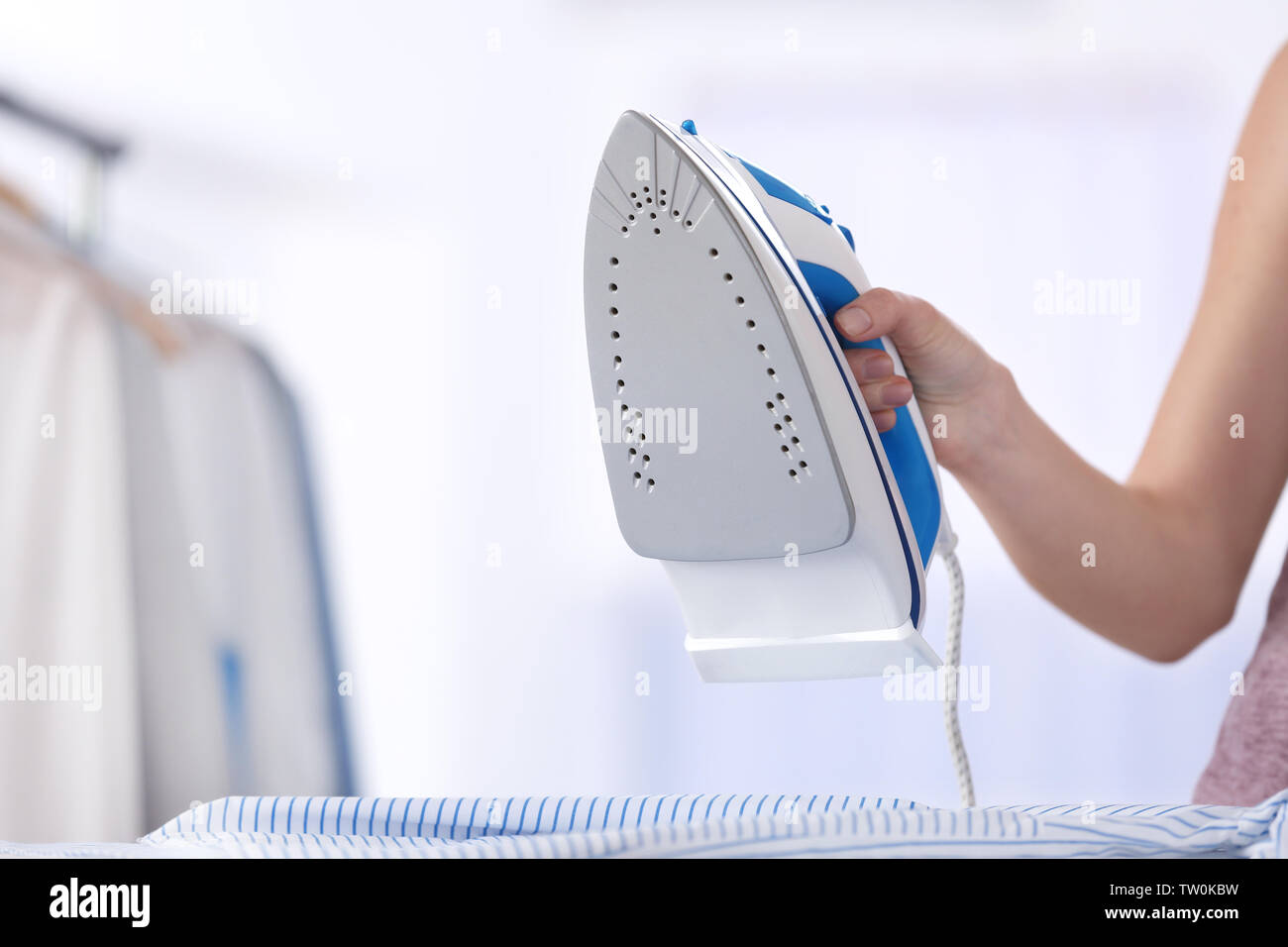 Female hand ironing clothes Stock Photo