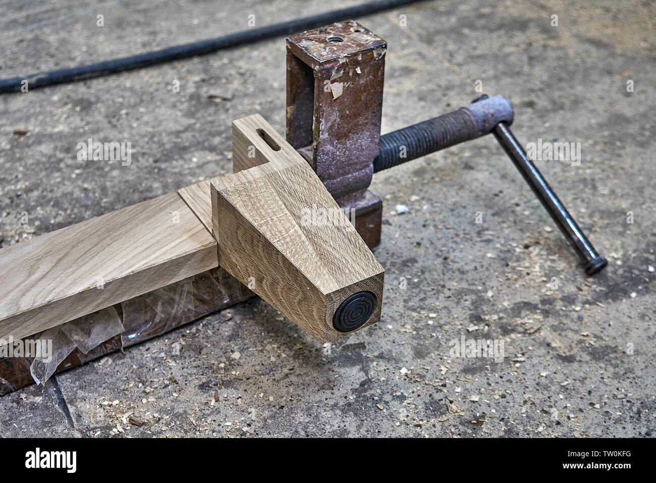 Furniture legs from solid oak. Closeup. Metal clamps tightening wooden
