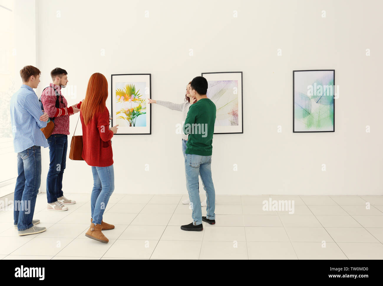 Young people in modern art gallery hall Stock Photo - Alamy