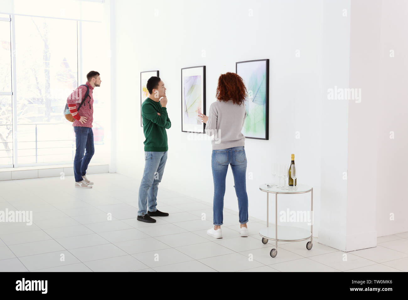 Young people in modern art gallery hall Stock Photo - Alamy