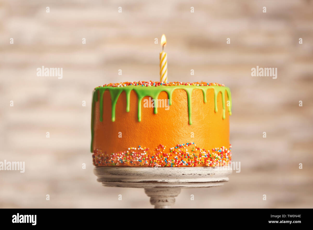 Birthday cake with one candle on blurred background Stock Photo - Alamy