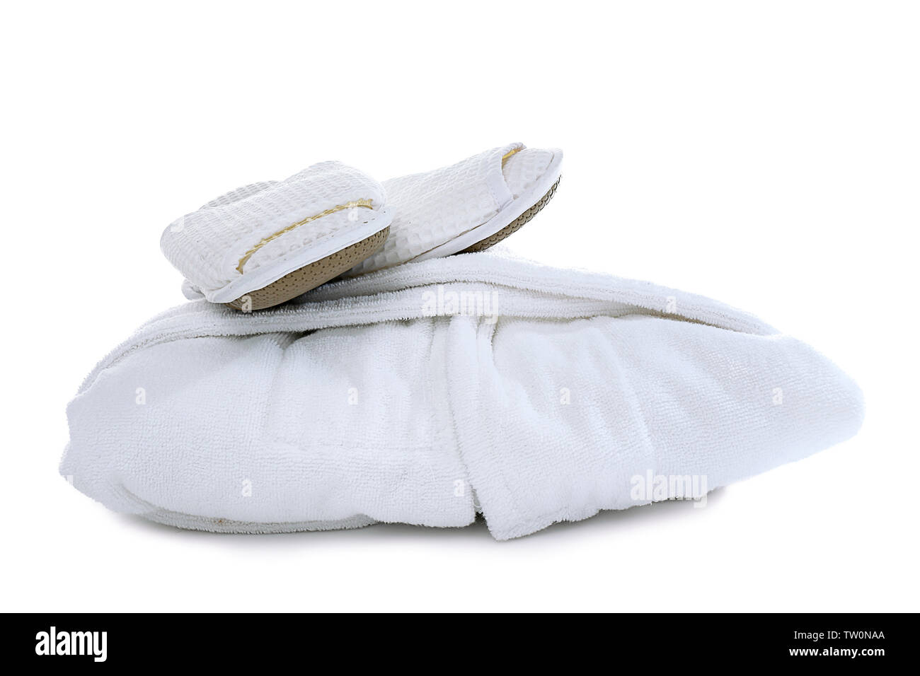 Folded spa bathrobe with slippers on white background Stock Photo