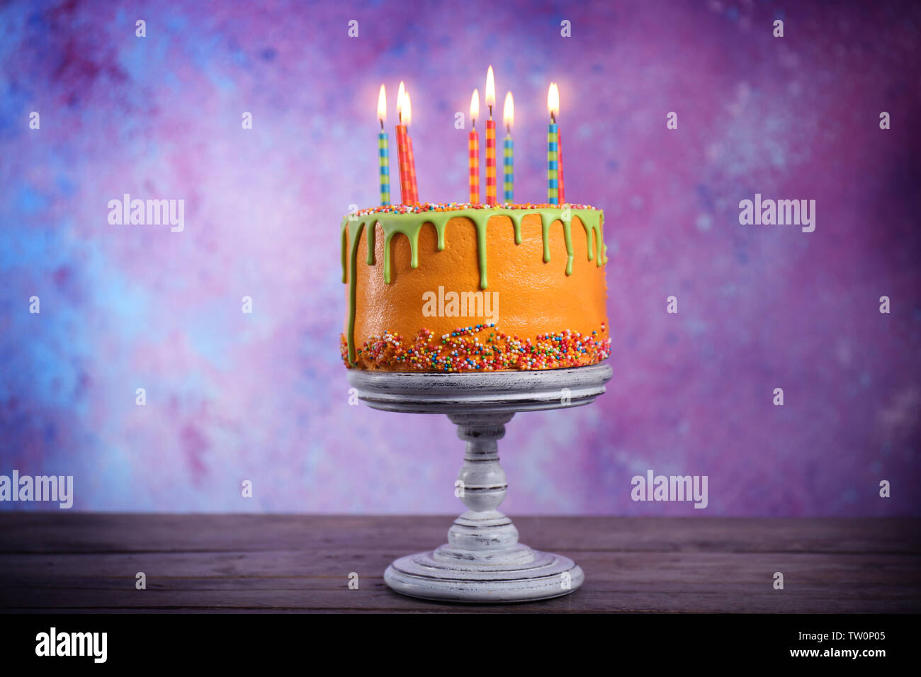Tasty birthday cake with candles on colorful background Stock Photo - Alamy