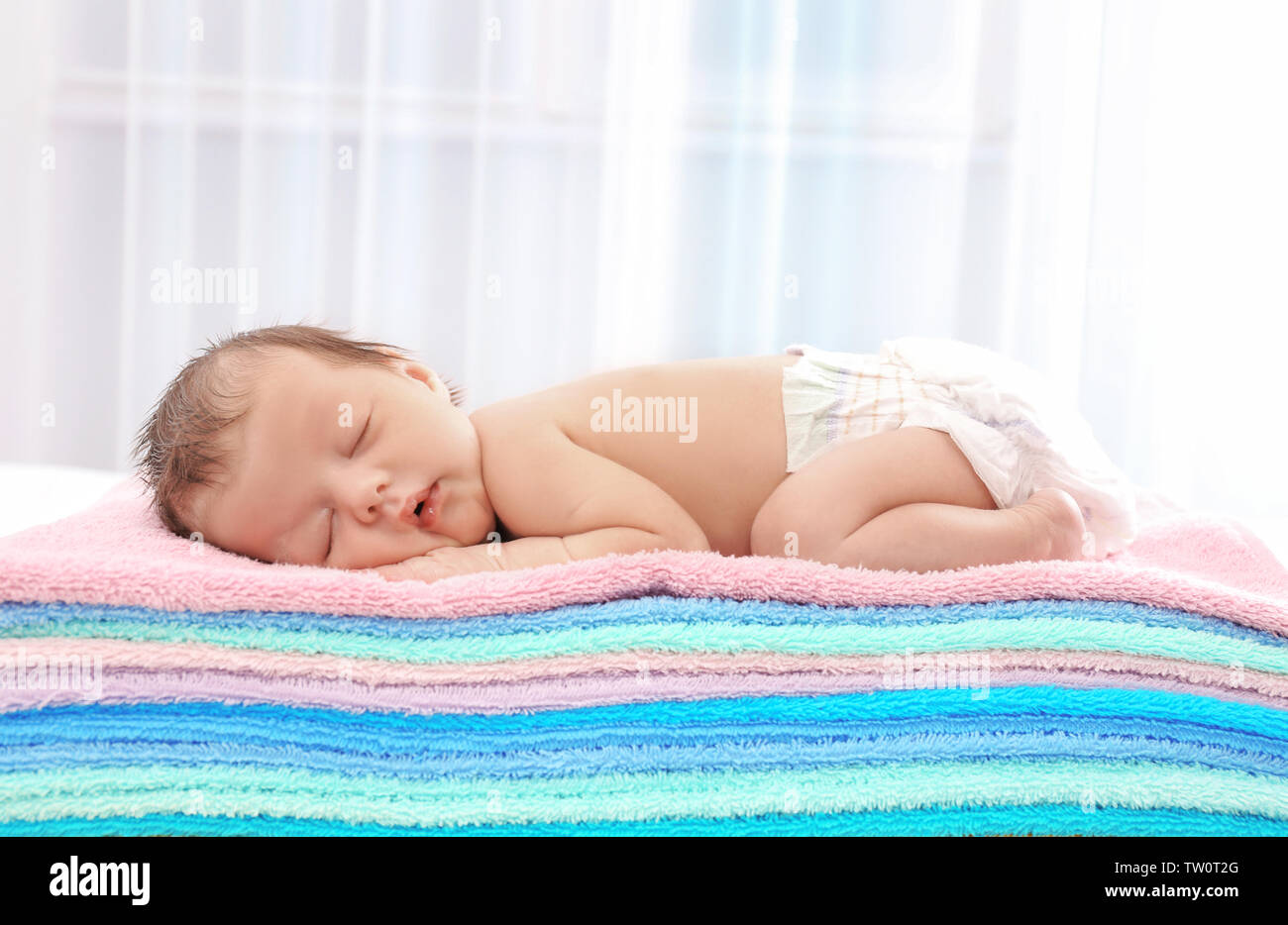Cute little baby sleeping on towels at home Stock Photo Alamy