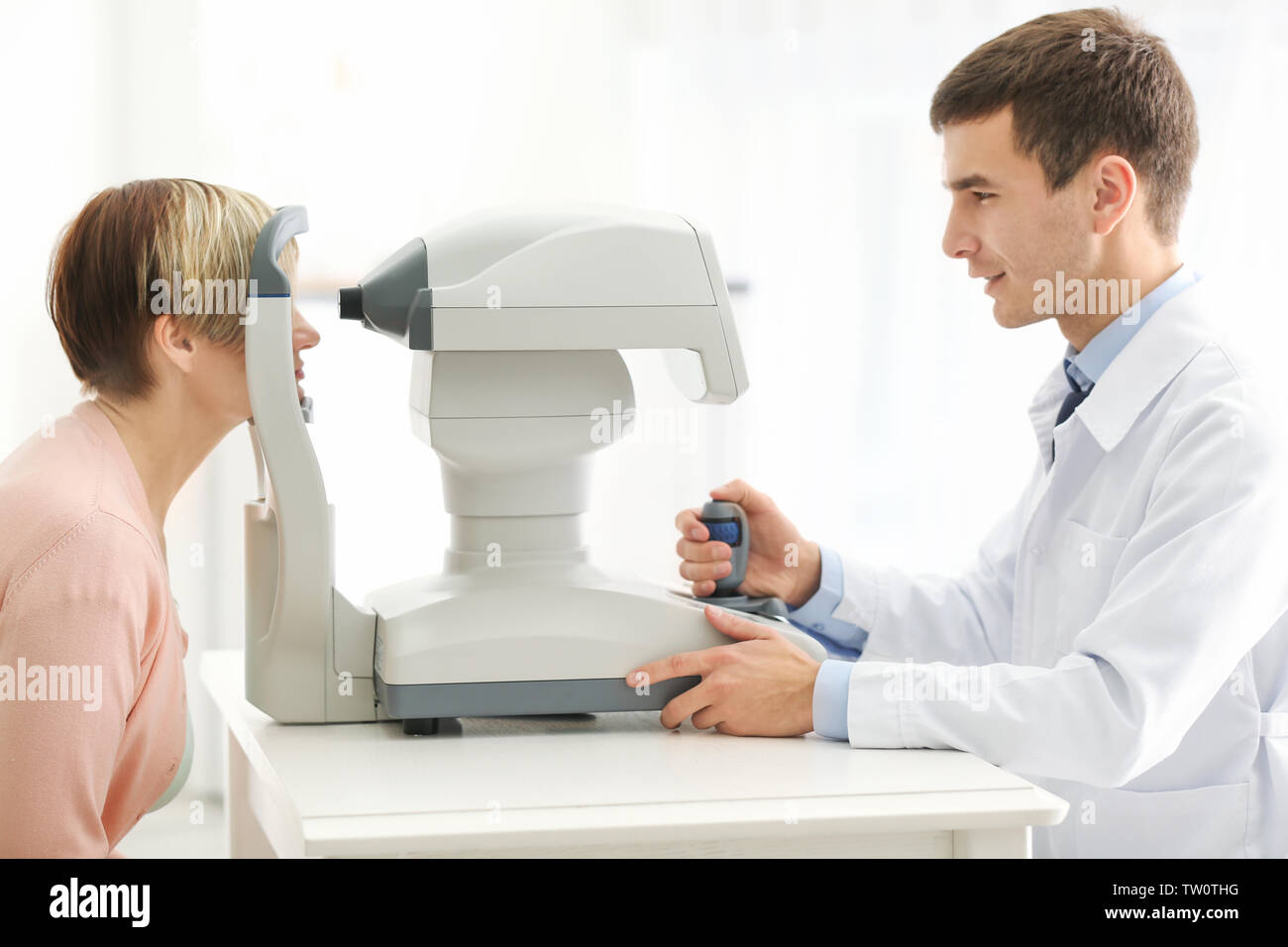 Ophthalmologist measuring intraocular pressure of woman in clinic Stock Photo