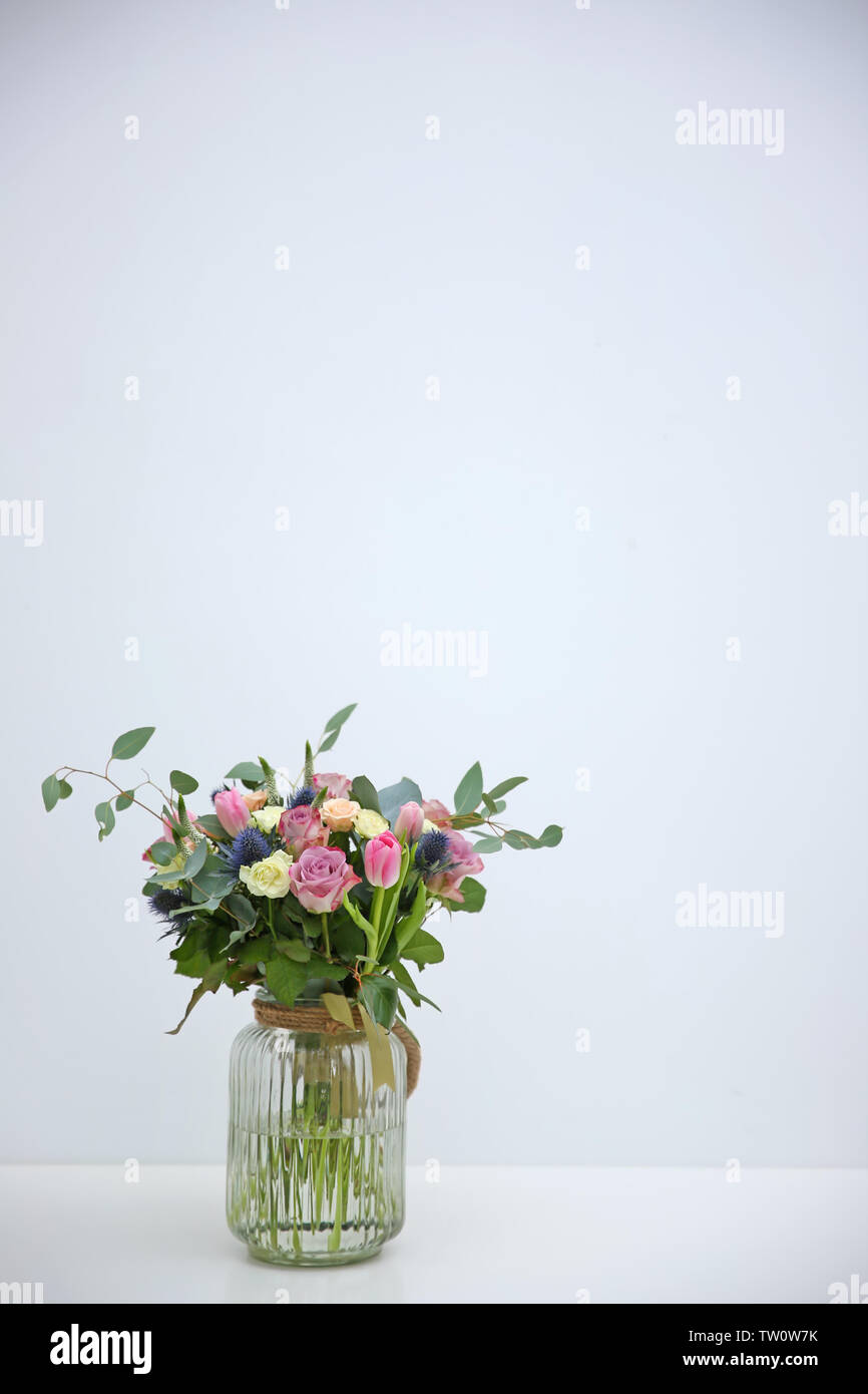 Glass vase with beautiful bouquet on light background Stock Photo - Alamy