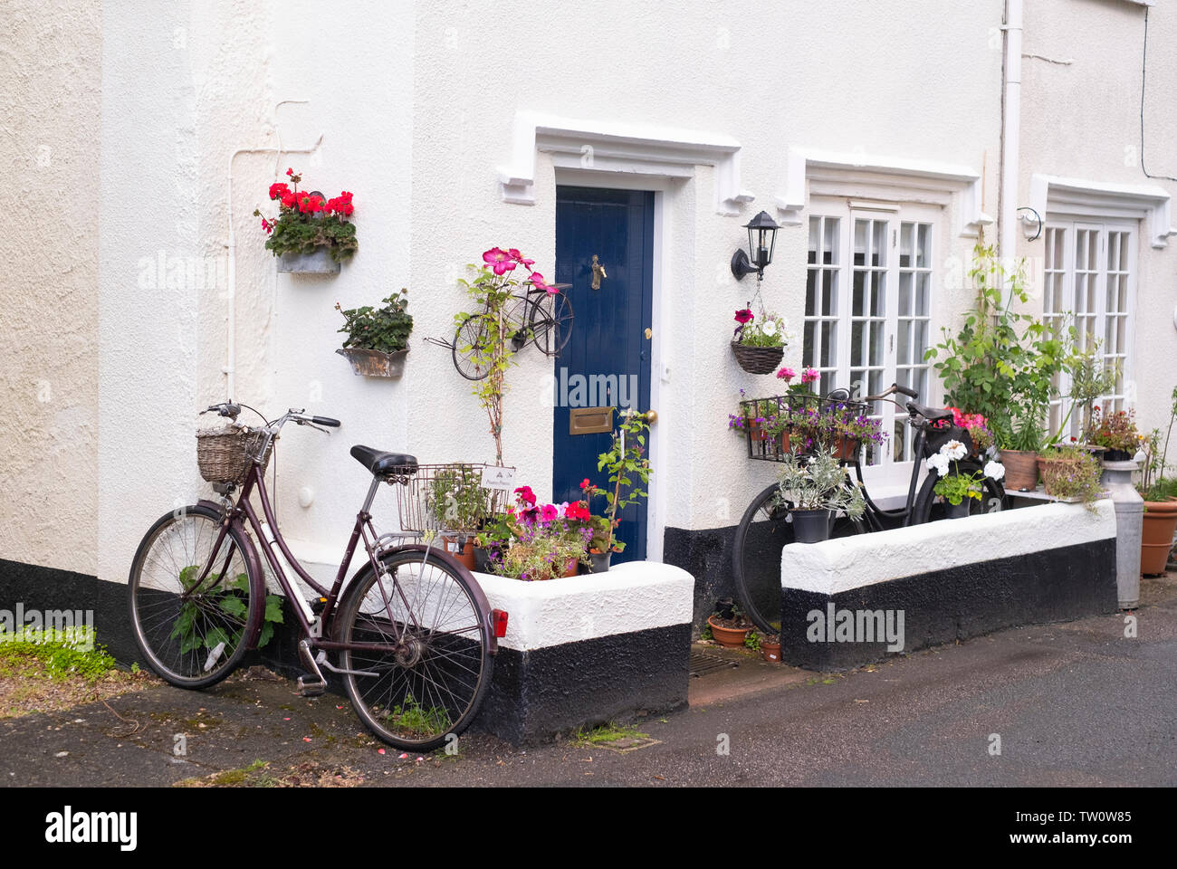 Bicycle with basket outside pretty cottage in England Stock Photo
