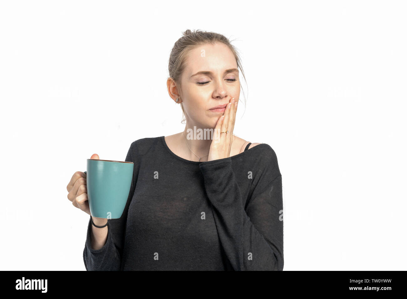 A woman drinks hot coffee and is sensitive to heat Stock Photo