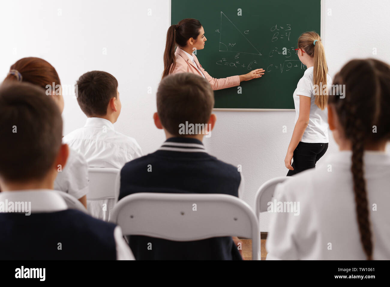Female teacher conducting lesson in classroom Stock Photo - Alamy